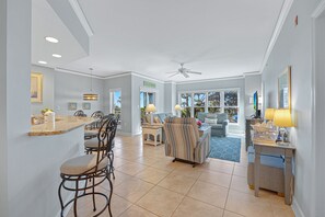 A spacious living area with a dining area, a ceiling fan, and a view of the outdoors. - Family Villa | Ocean/Pool Views, Balcony, Bikes, Close to Shops/Dining (Hilton Head Island)