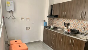Uma cozinha compacta com armários de madeira, fogão a gás e painel de azulejos.