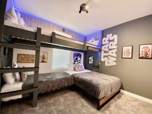 A bunk bed room with Star Wars decor, including wall art and LED lights.