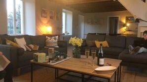 A cozy living room with two sofas, a coffee table, and a vase of flowers.