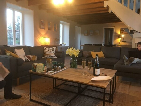 A cozy living room with two sofas, a coffee table, and a vase of flowers.