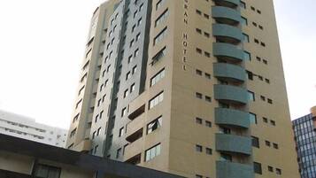 A tall hotel building with multiple balconies and a sign reading "Allianz Grand Hotel".