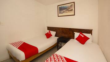 Two single beds with wooden frames, white bedding, and red accents.