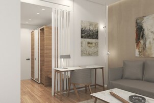 Una sala moderna con un mueble de madera, un escritorio con lámpara, un sofá gris y arte abstracto en las paredes.