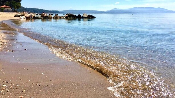 A beach with clear water, pebbles, and rocks. - Nikiti Beach (Sithonia)