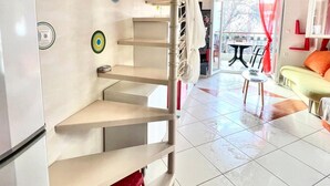 A modern living room with a staircase, a sofa, and a dining area. - Nikiti Beach (Sithonia)