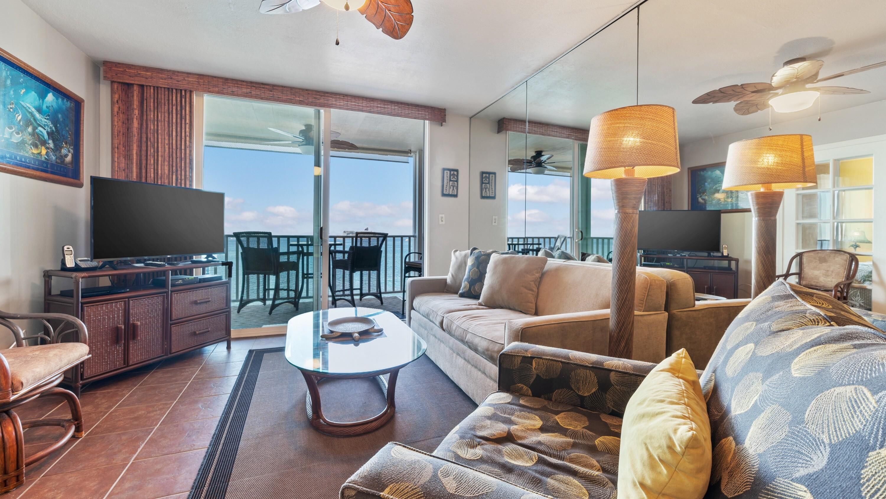 Un vaste espace de vie avec balcon, aménagé avec des canapés, une table basse et un téléviseur.