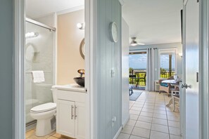 A bathroom with a toilet, shower, and sink. There is a balcony with a view of the ocean. - Direct Oceanfront View - Beachfront Villa (Hilton Head Island)