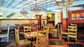 A restaurant with wooden tables and chairs, a high ceiling with skylights, and a mural on the wall. - #1312 Winter and Summer Adventure Awaits! (Brian Head)