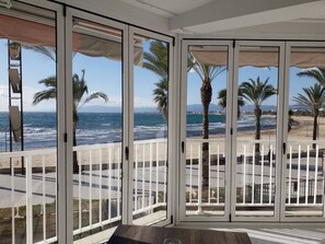 A room with a view of the ocean and palm trees. - Remarkable 4-Bed Beach Apartment in Salou (Salou)
