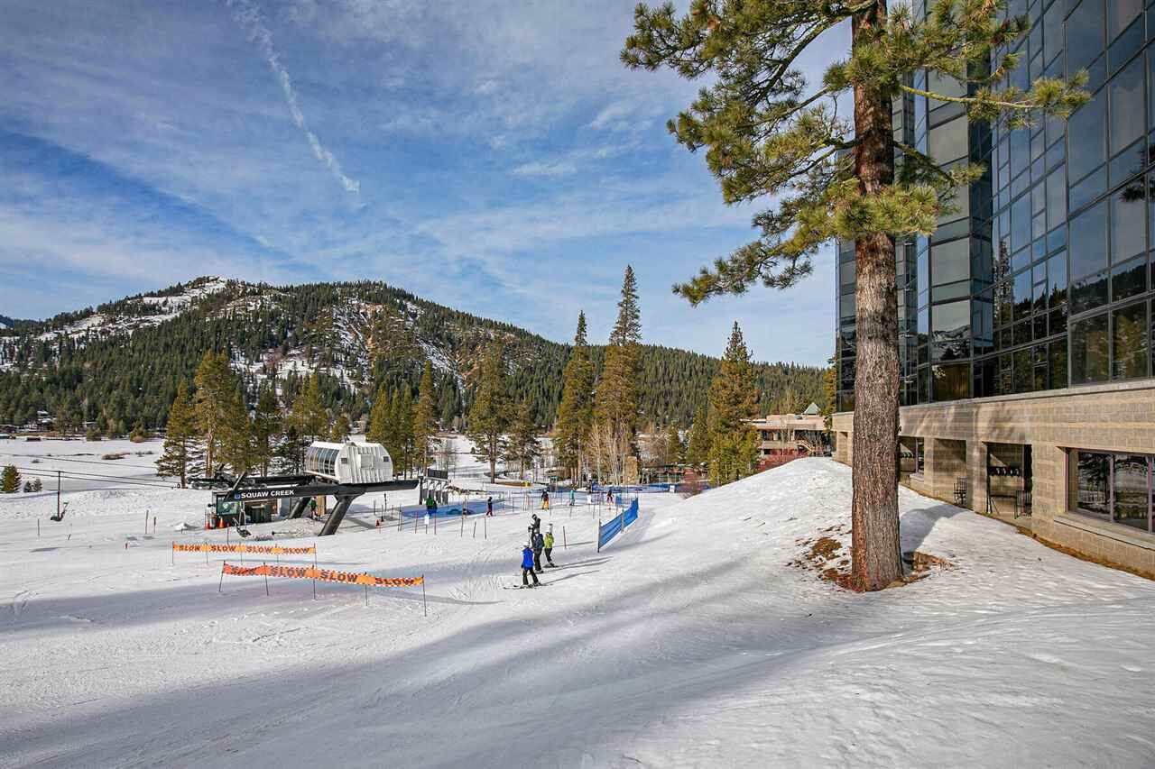 A ski slope with a modern building and a mountain in the background.