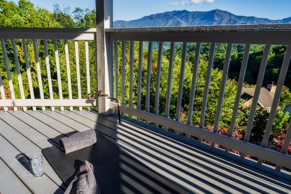 A wooden deck with a white railing, a glass of water, and a towel.