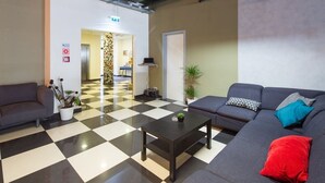 A lobby with a checkered floor, a sofa, a coffee table, and a potted plant. - Di Verdi Imperial Hotel (Budapest)
