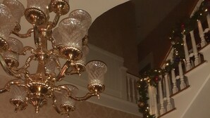 Eine prächtige Treppe mit einem Chandelier, verziert mit festlichen Girlanden und Schmuck.