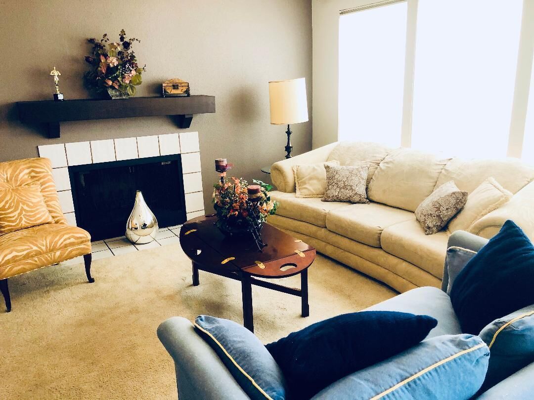 A living room with a fireplace, a sofa, a coffee table, and a lamp.