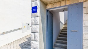 A blue door with a metal handle, a stairway leading to a landing, and a blue sign with the word "SOBE" on a white wall. - Rooms Nikola (Dubrovnik)