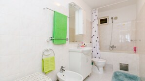 A bathroom with a sink, toilet, shower, and a mirror. - Rooms Nikola (Dubrovnik)