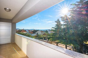 Un balcón con vistas a una zona residencial y un cielo despejado.