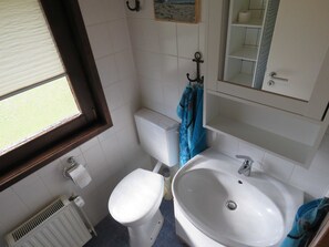 Un bagno con il water, un lavandino e una finestra.