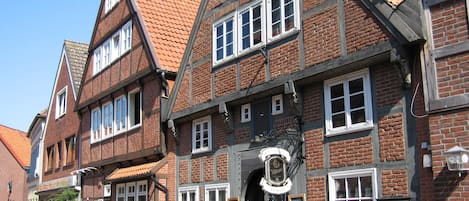 A traditional half-timbered building with multiple windows and a signboard.