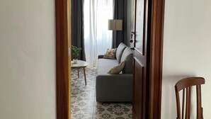 Una sala de estar con un sofá, una mesita y una lámpara.