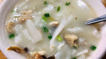 A bowl of soup with noodles and green onions.