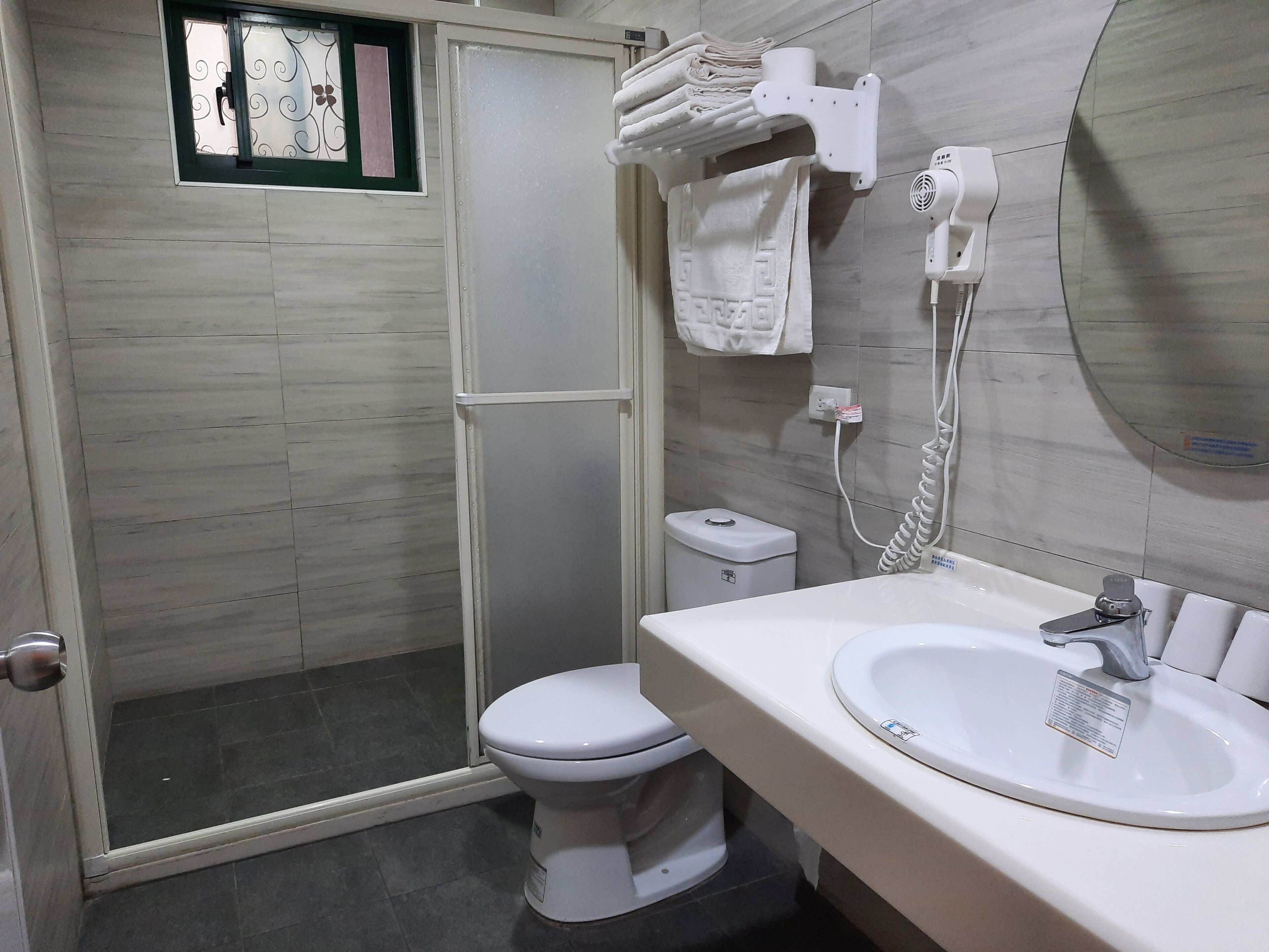 A bathroom with a shower, toilet, and sink.
