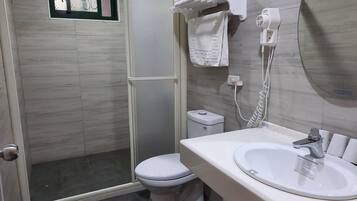 A bathroom with a shower, toilet, and sink.