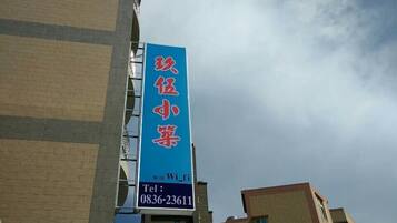 Located in a modern building, this property features a prominent sign with Chinese characters and a flat facade with windows.