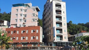 A multi-story building with balconies and a rooftop garden. - Jiu Wu Xiao Zhu (Nangan)
