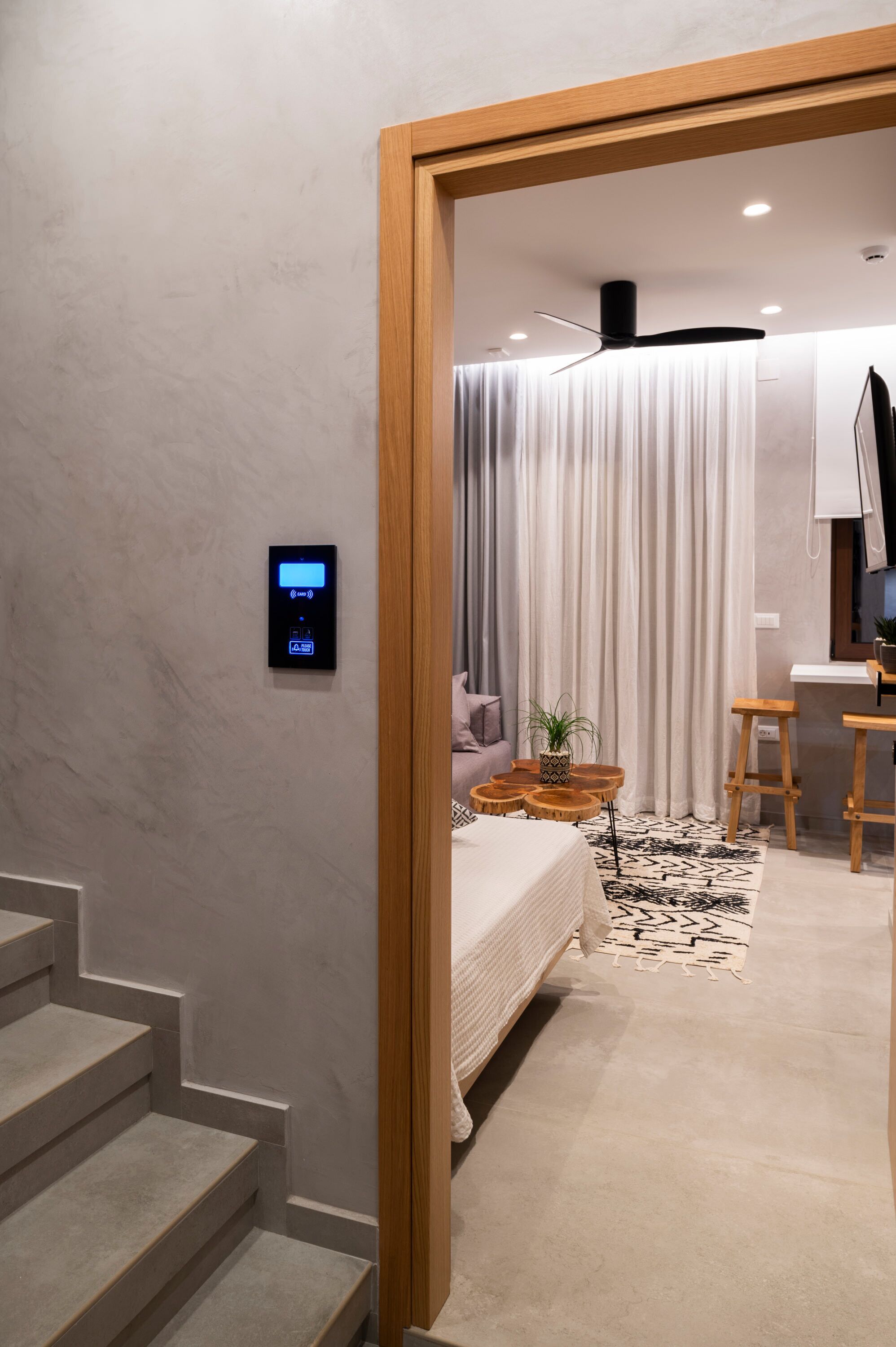 A modern bedroom with a bed, bedside table, and a small desk area.
