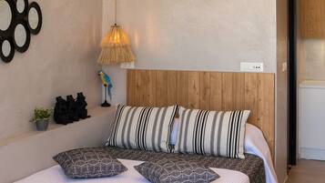 Ein Schlafzimmer mit einem hölzernen Kopfteil, gestreiften Kissen und einer gemusterten Bettdecke.