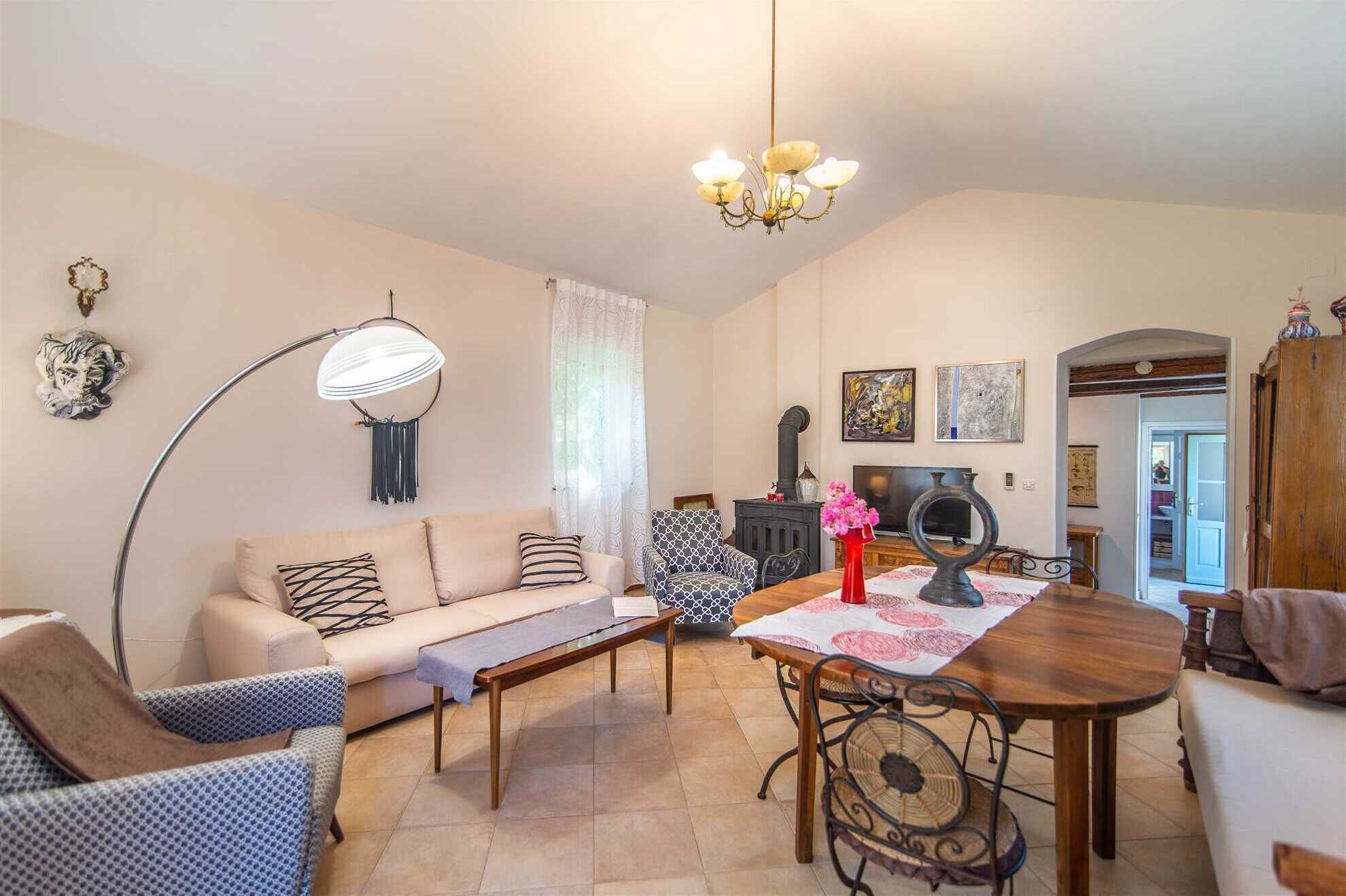 A living room with a sofa, a dining table, a fireplace, and a TV.