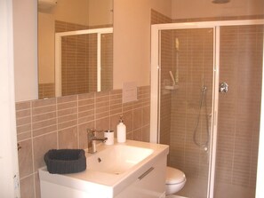 Een douche, een haardroger, zeep, toiletpapier