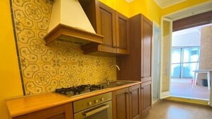 A kitchen with wooden cabinets, a gas stove, and a patterned backsplash.