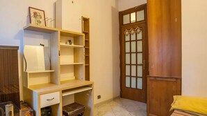 A room with a wooden desk, a small stool, and a door with glass panels.