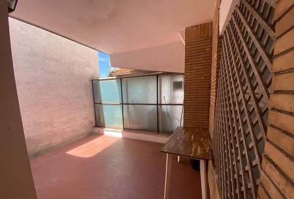 A corridor with a brick wall on the right and a glass partition on the left.