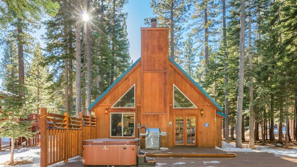 A wooden cabin with a deck, a hot tub, and a chimney. - BlackDog Hideaway_Hot Tub, (2) Arcades, Foosball, PingPong, Smart Tv's, Cable + HOA Amenity Passes (Truckee)
