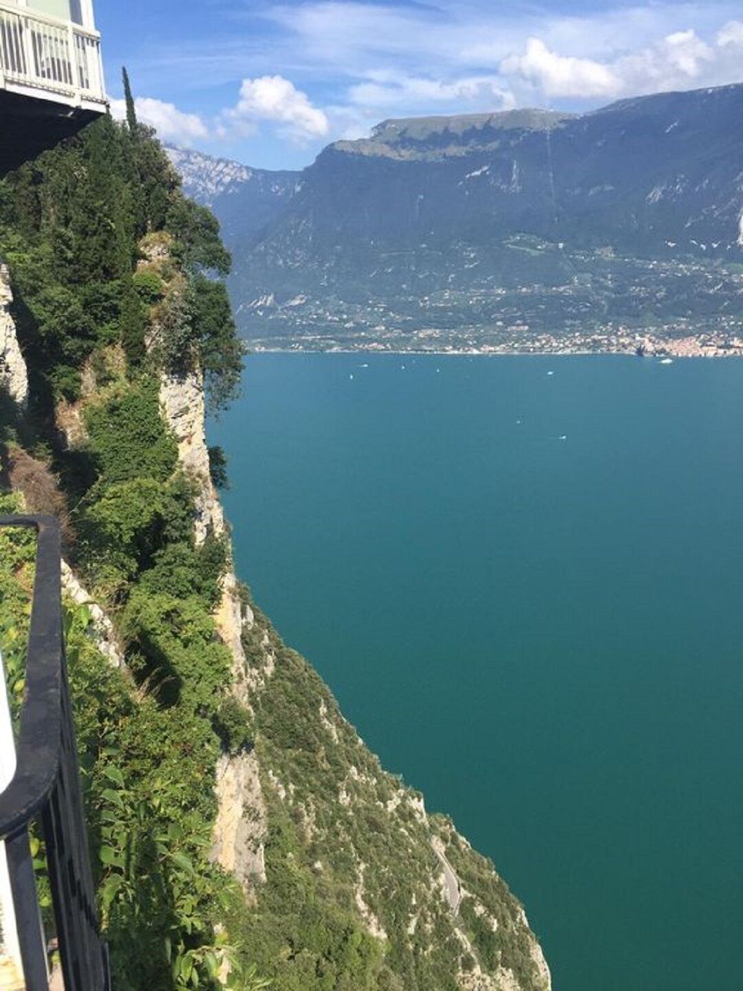 Eine Küstenklippe mit Blick auf ein ruhiges Meer und entfernte Berge.