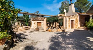 Un edificio de piedra con tejado de tejas, puerta de madera y una ventana pequeña.