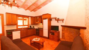 A compact living space with a kitchen, dining area, and seating. - Tranquil country house Can Guillem with pool, terrace, Wi-Fi and air conditioning (Campos)