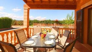 Ein Balkon mit Esstisch, Stühlen und Blick auf die umliegende Landschaft.