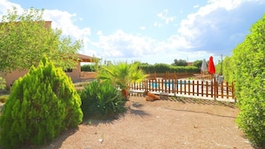 Ein Garten mit Pool, Holzzaun und einem Gebäude.