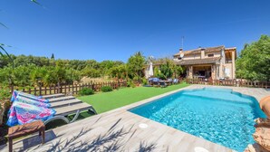 A swimming pool with lounge chairs, a wooden deck, and a fenced garden area. - Finca "Son Antem" with private pool, garden, terrace, and Wi-Fi (Llucmajor)