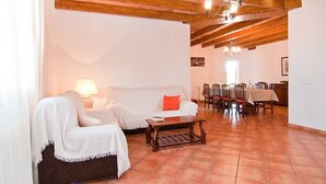A living room with a sofa, a coffee table, and a dining area with chairs and a table. - Can Mates Nou, private pool, free Wi-Fi (Campos)