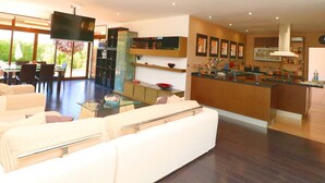 Una sala de estar moderna con un sofá, una mesa de centro de vidrio y un televisor.