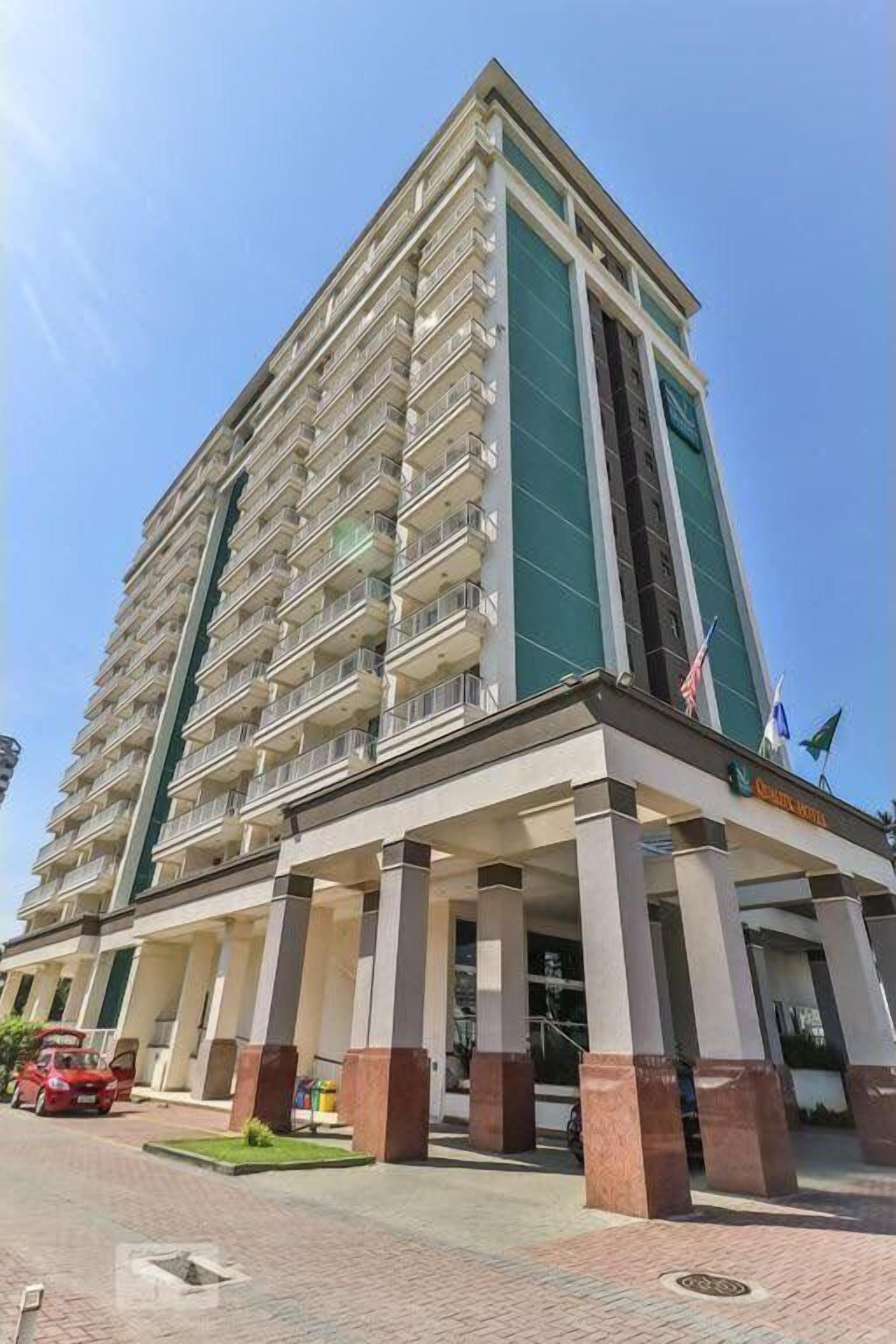 A tall, multi-story hotel with a prominent entrance and a flag on top.