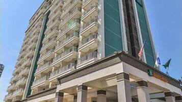 A tall, multi-story hotel with a prominent entrance and a flag on top.
