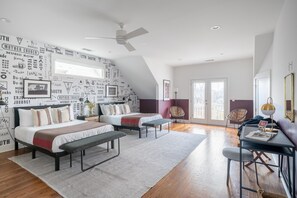 Relax in this stylish loft-style bedroom with a large bed, desk area, and floor lamp.