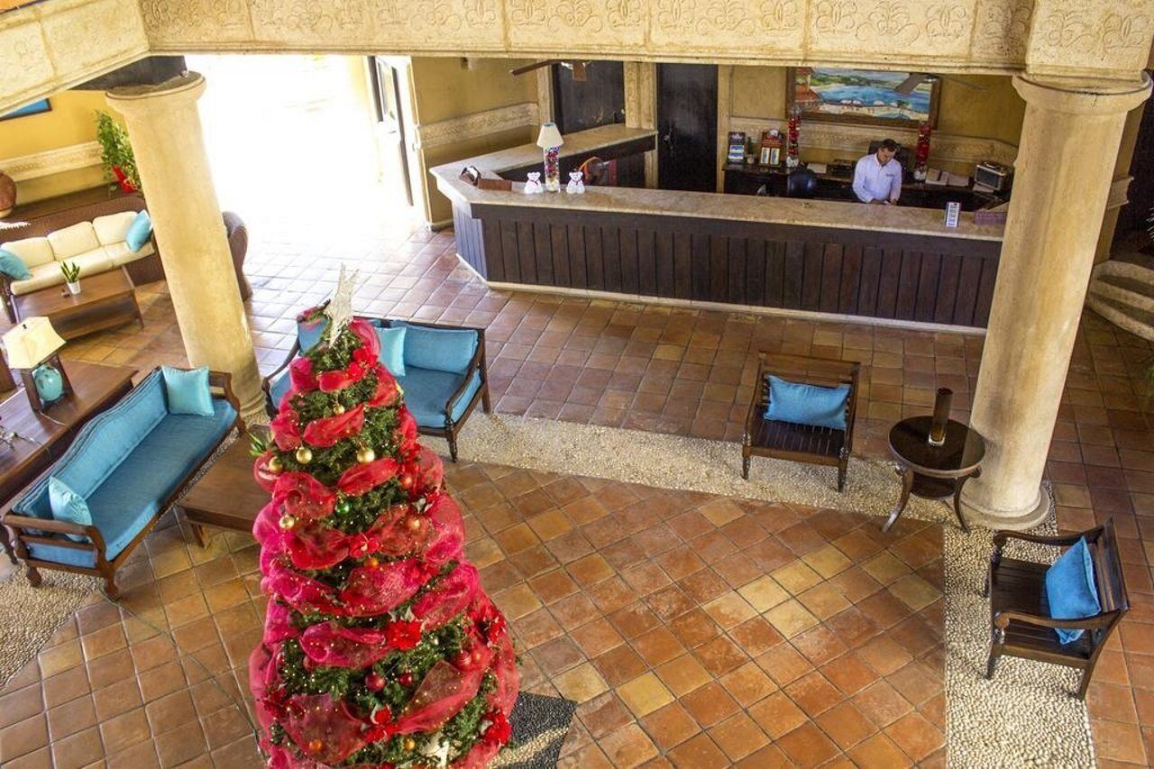 Un hall d’entrée avec un comptoir de réception, plusieurs canapés et un sapin de Noël.